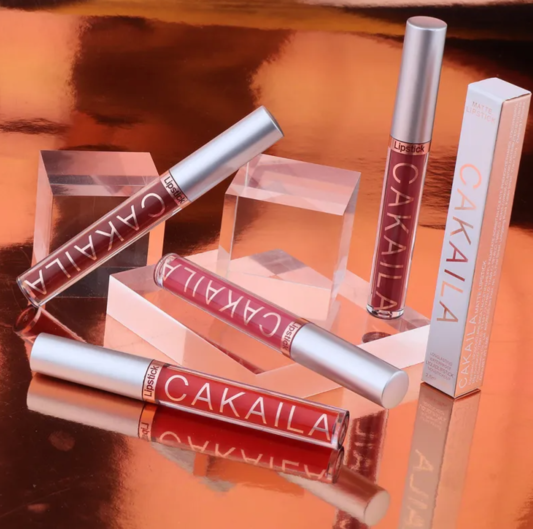 VelvetGlow™ liquid lip colors in red and berry shades displayed with a product box
